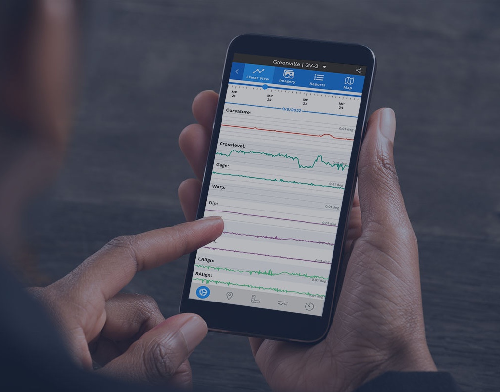 Closeup of a man's hands using a phone, with a mockup of railway linear data displayed on the phone